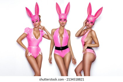Sexy blonde woman posing in latex pink costume and pink bunny mask on white background. Easter bunny concept. Latex lingerie. Naughty girl. Halloween costume. Lingerie fashion.
