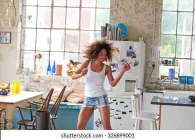 Sexy fată braziliană dans la domiciliu purtând pantaloni scurți de pijama verificat aruncarea părului înapoi