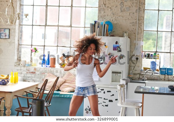 Sexy brazilian girl dancing at home
wearing checked pajamas shorts throwing hair
back