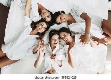 Sexy bride & bridesmaids lying in bed before wedding