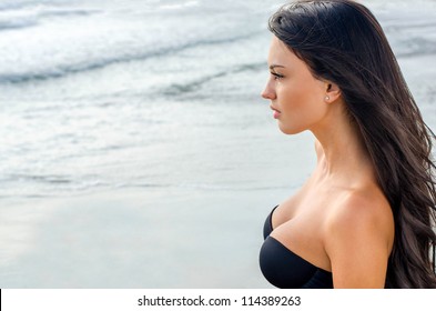 Sexy brunette girl looking at the sea
