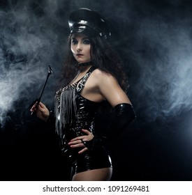 Sexy brunette woman mistress holding whip,over dark backgroynd
