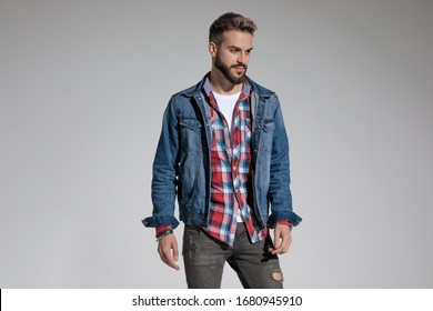 Sexy Casual Man Wearing Denim Jacket Standing And Posing With Style On Gray Studio Background