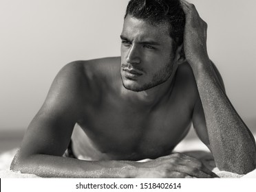 Sexy closeup portrait of handsome topless male model on the beach. Black and White.