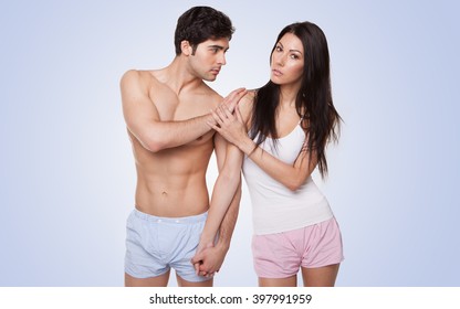 sexy couple in their underwear arguing looking at the camera