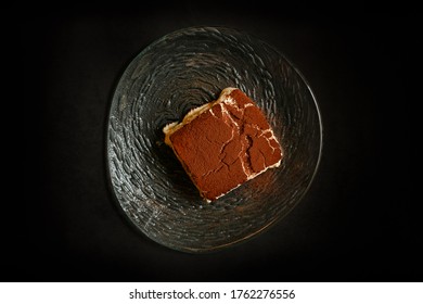 Sexy und köstlich hausgemachte Tiramisu aus Mascarponkäse mit Kakaopulver und auf Glasplatte serviert
