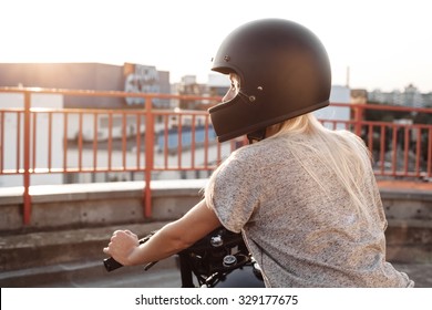 Sexy Fashion Female Biker Girl With Black Full Face Motorcycle Helmet. Young Blonde Woman  Sitting On Vintage Custom Motorbike. Outdoors Lifestyle Portrait