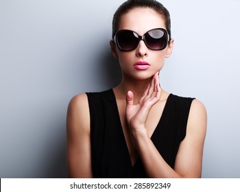 Sexy Fashion Female Model In Trendy Sun Glasses Posing On Blue Background. Closeup Portrait