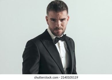 Sexy Fashion Model Looking At The Camera With A Tough Look On His Face And Wearing A Black Tux