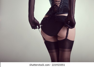 Sexy female buttocks in burlesque lingerie, studio shot on white background  
