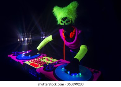 sexy female DJ mixes in a club  in UV fluorescent costume