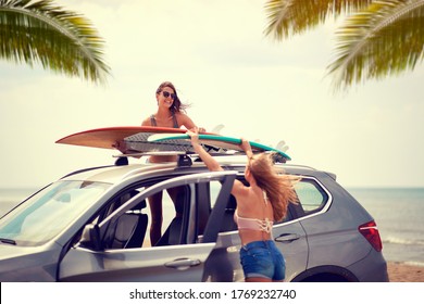 Sexy Female Surfers Packing The Boards On Top Of The Car