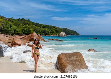 A sexy female wearing a bikini on the Anse Lazio beach on a tropical island in Seychelles