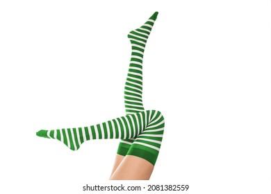Sexy female well groomed long legs in green striped stockings. Leprechaun girl, isolated on white.