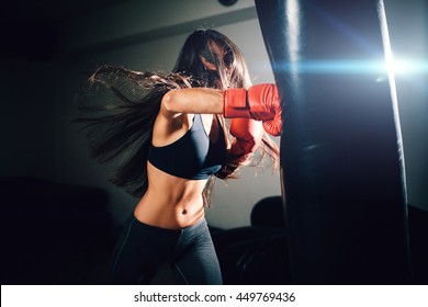 sexy fighter girl punching actively. motion long hair