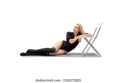 Sexy Fit Caucasian Woman In Black Sports Body And Gaiters Lying On Side On A Mat And Lean On A Chair, Isolated On White. Fitness Promotion, Advertising, Motivation, Dancer, Sport, Female Health