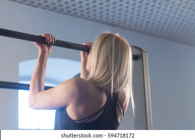 Sexy Fit Woman Performing Pull Ups In A Bar.