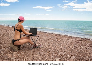 Sexy Freelance Girl In An Erotic Swimsuit Working At A Computer On The Ocean, Free Work Not Tied To A Place Of Residence