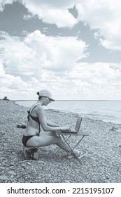 Sexy Freelance Girl In An Erotic Swimsuit Working At A Computer On The Ocean, Free Work Not Tied To A Place Of Residence