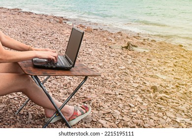 Sexy Freelance Girl In An Erotic Swimsuit Working At A Computer On The Ocean, Free Work Not Tied To A Place Of Residence