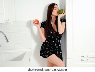Sexy girl with apple and avocado in the kitchen