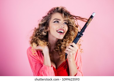 Sexy girl with curly hair holds hairdresser equipment. Beauty industry profession. Hairdresser. Makeup and cosmetics for skincare. Beauty and style. Isolated on pink background.
