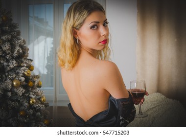 Sexy Girl In A Dressing Gown Christmas Tree The Evening With A Glass Of Wine.