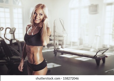 Sexy Girl With Headphones Relaxing In The Gym