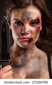 Sexy girl holding a knife. Woman with blood on face. 