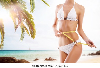 Sexy Girl Measuring Perfect Body. Summer Beach Background. Fat Lose, Sport And Fitness Concept.