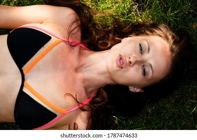 Sexy Girl In Swimsuit Relax On Grass. Brunette Girl With Open Mouth And Blue Eyes. Female Beauty. Summer Fashion Concept. Sin Care And Health.