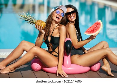 Sexy Girls In Swimsuits Having Fun In Summer. Happy Women With Healthy Tanned Body In Stylish Sunglasses And Fashion Swimwear Enjoying Vacation Near Pool At Resort. High Resolution.