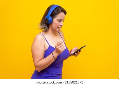 Sexy Hispanic Mature Woman Using Mobile Phone And Headphones