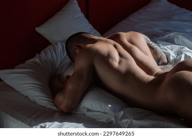 Sexy male round buttocks, Sexy shape butt. Muscular hunk. Naked man model in bed. Gay sexy model. Perfect shoulders and chest. Muscular sexy man with naked torso. Hunk with athletic body in bed.