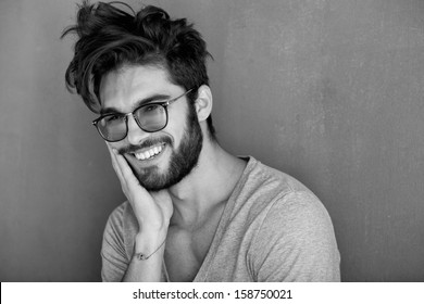 Sexy Man With Beard Smiling Big Against Wall
