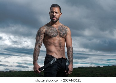 Sexy man with naked torso. Brutal angry gang man lifestyle, serious handsome guy. Strong muscular male body, muscles guy. Tattooed and elegant hipster.