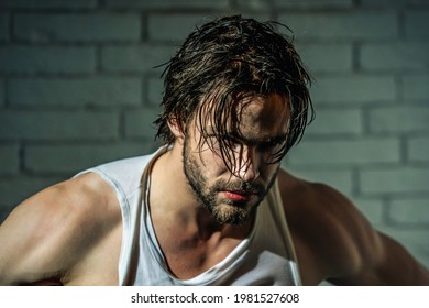 Sexy man with wet hair in singlet. Muscular shoulders. Masculinity, power and strength.