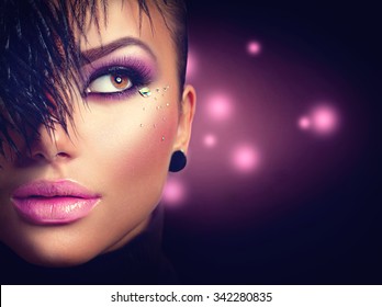 Sexy Model Girl Face Close Up With Holiday Bright Purple Make Up Over Black Background. Beauty Woman With Vivid Makeup And Feather Hairstyle. Beautiful Glamour Lady. Party Style