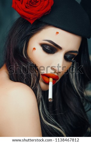Sexy model is posing in a studio wearing black hat