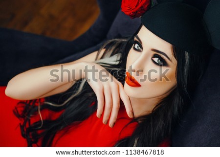 Sexy model is posing in a studio wearing black hat