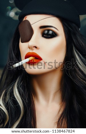 Sexy model is posing in a studio wearing black hat