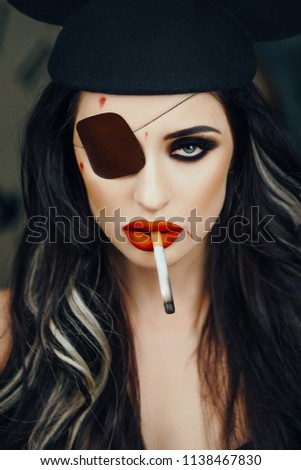 Sexy model is posing in a studio wearing black hat
