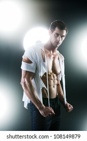 Sexy Muscular Male In White Ripped Shirt In Studio