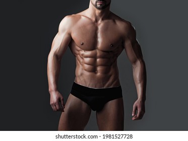 Sexy muscular men with bare naked body torso. Naked body and strong torso of male athlete in underwear pants posing with bare chest and belly on grey background.