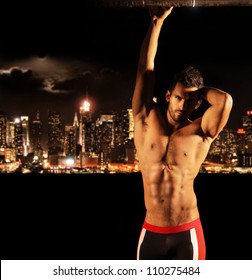 Sexy Muscular Young Shirtless Man At Night With City Lights And Skyline In Background With Copy Space