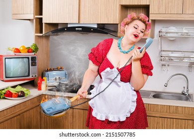 Sexy Pinup Plus Size Caucasian Woman In Cook's Chatting By Phone On The Kitchen, She Put The Phone By Mistake In The Frying Pan And It Burns. Ð¡oncept Of Body Positivity