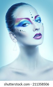 Sexy portrait of female with multicolor make up in cold tones in studio