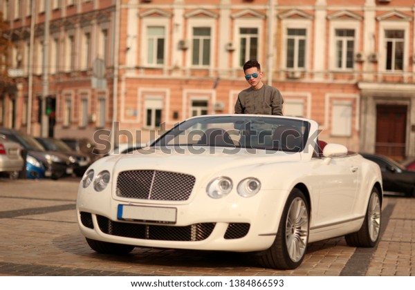 Sexy, rich, guy. Model. Man. Male. Bentley,\
Success, successful. supercar, car, super car. Attractive. Comfort.\
Lux, luxury, Vehicle, driver. Auto, automobile.  Happy dream.\
Young.