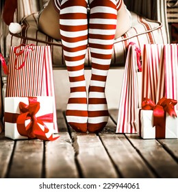 Sexy Santa Woman Legs. Christmas Shopping Concept. Xmas Gift Box