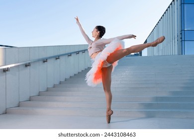 Sexy Sensual Graceful Slim Professional Caucasian Ballet Dancer in Rose Pink Tutu Dreass Whie Posing In Dance Flying Pose On Blue Stairs In Stretched Pose Outdoor. Horizontal Image